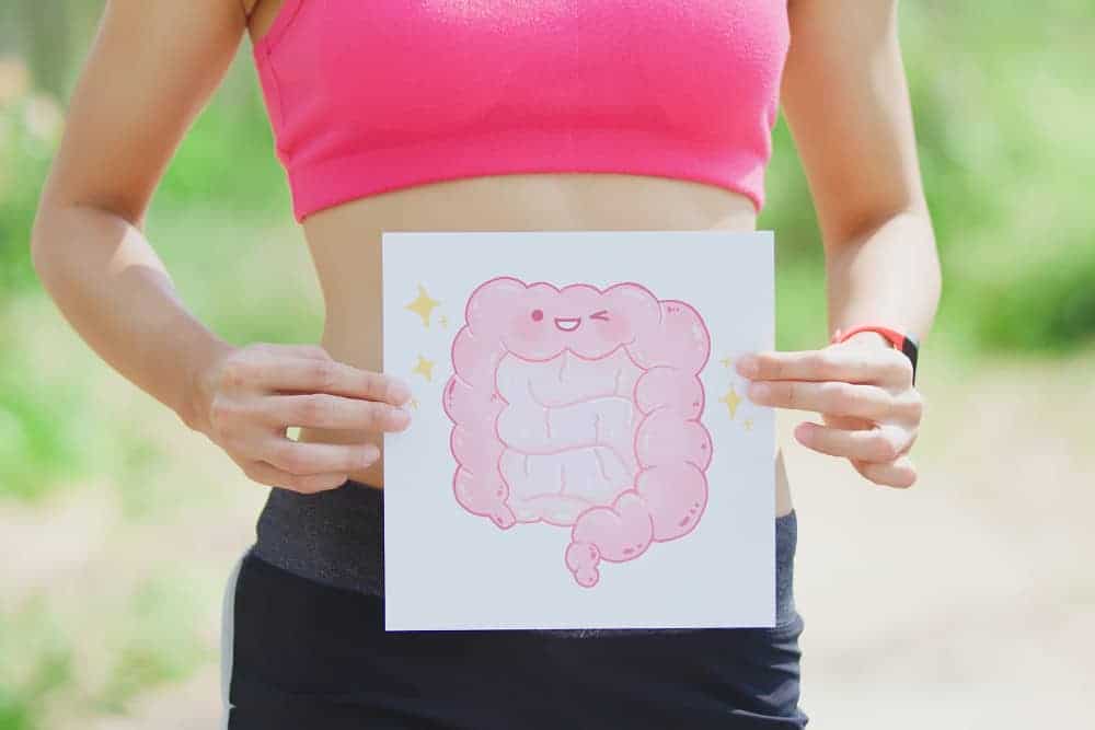 Frau hält sich Zeichnung mit Darm vor den Bauch