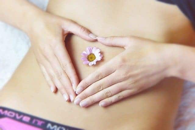 Frauenbauch mit Gänseblümchen im Bauch