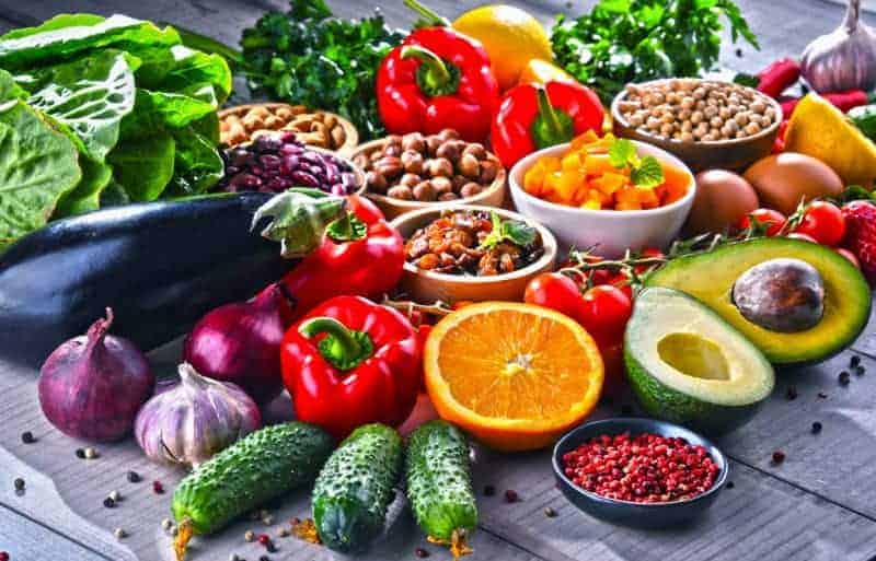 Gesunde, natürliche und bunte Ernährung mit Obst, Gemüse und Nüssen auf Holztisch gegen Entzündungen im Körper