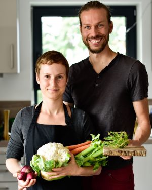 Maria & Marco mit frischem Gemüse vor hellem Hintergrund