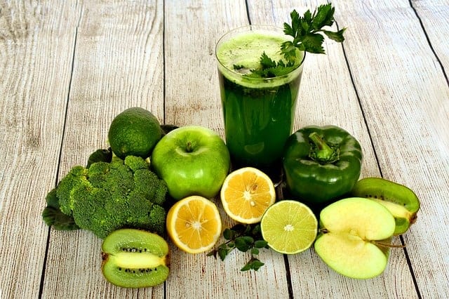 Grünes Obst und Gemüse auf Holztisch mit grünem Shake