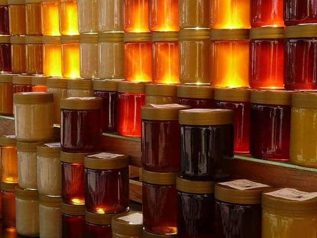 Eine leuchtende Wand aus verschiedenen Honig-Gläsern