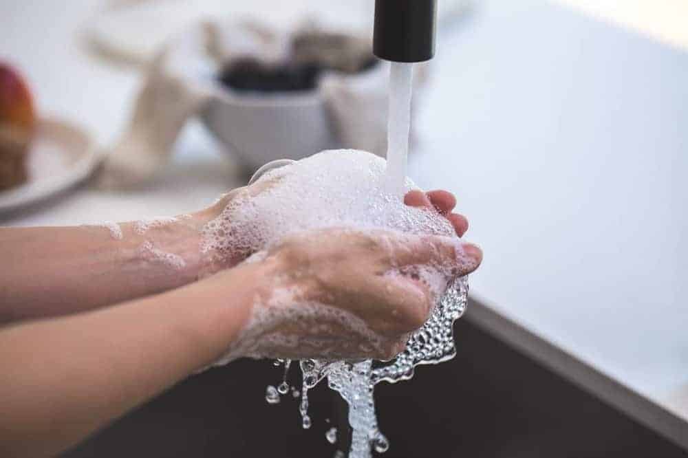 Hände in Nahaufnahme unter fließendem Wasser mit Seife