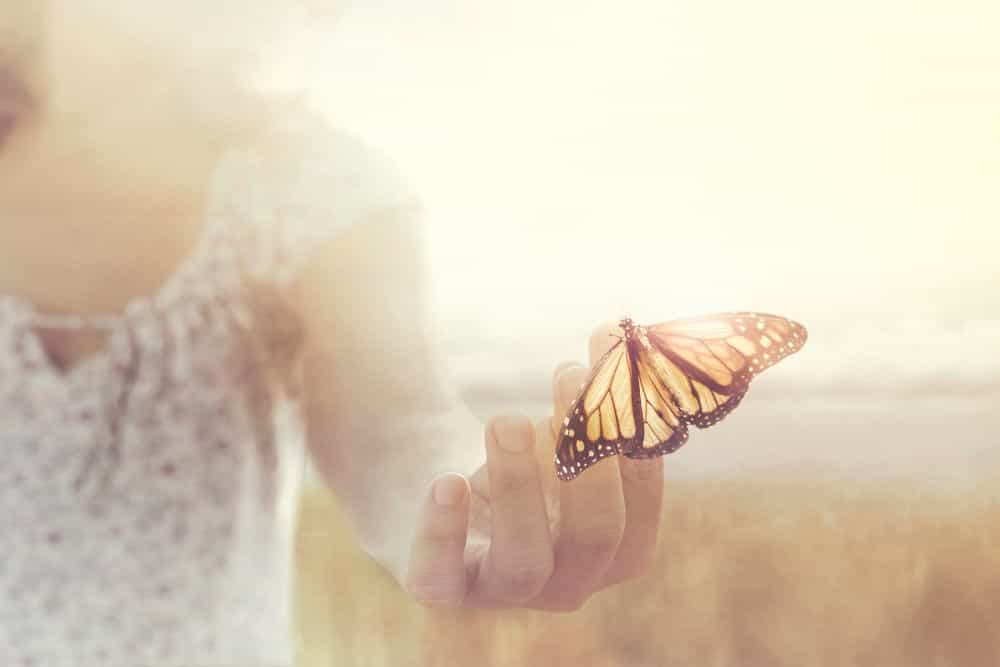 Frau hält einen Schmetterling