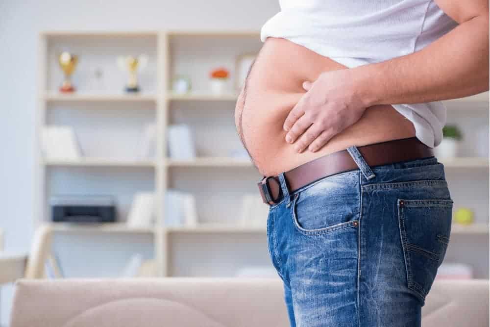 Risikofaktoren Stoffwechselerkrankungen Mann greift sich an den dicken Bauch