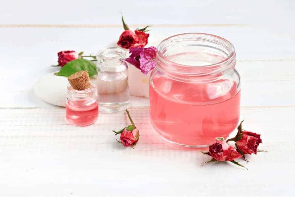 Rosenwasser mit Rosenblüten
