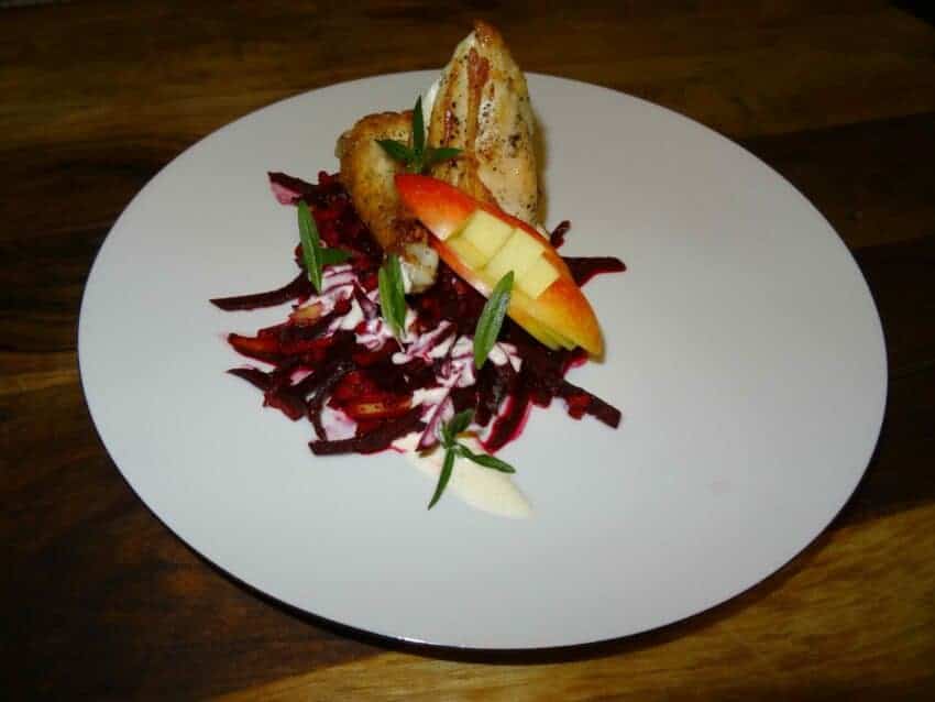 Rote Beete Apfel Salat auf einem Teller auf Holzhintergrund