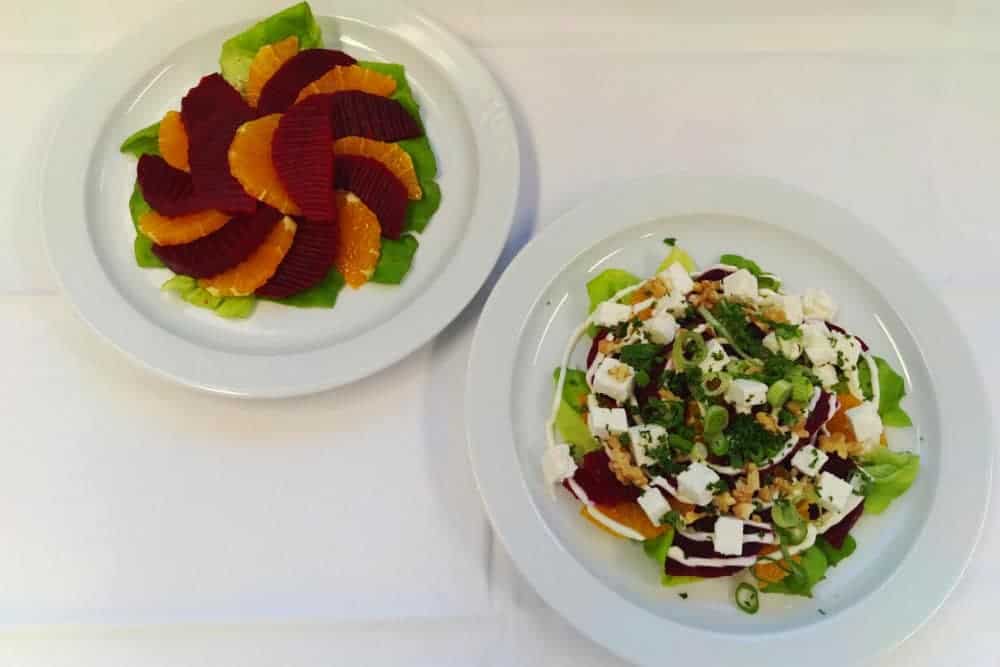 zwei bunte Salate auf weissen Telelrn auf weissem Tischtuch
