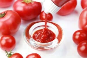 Tomaten und Ketchup auf weissem Hintergrund