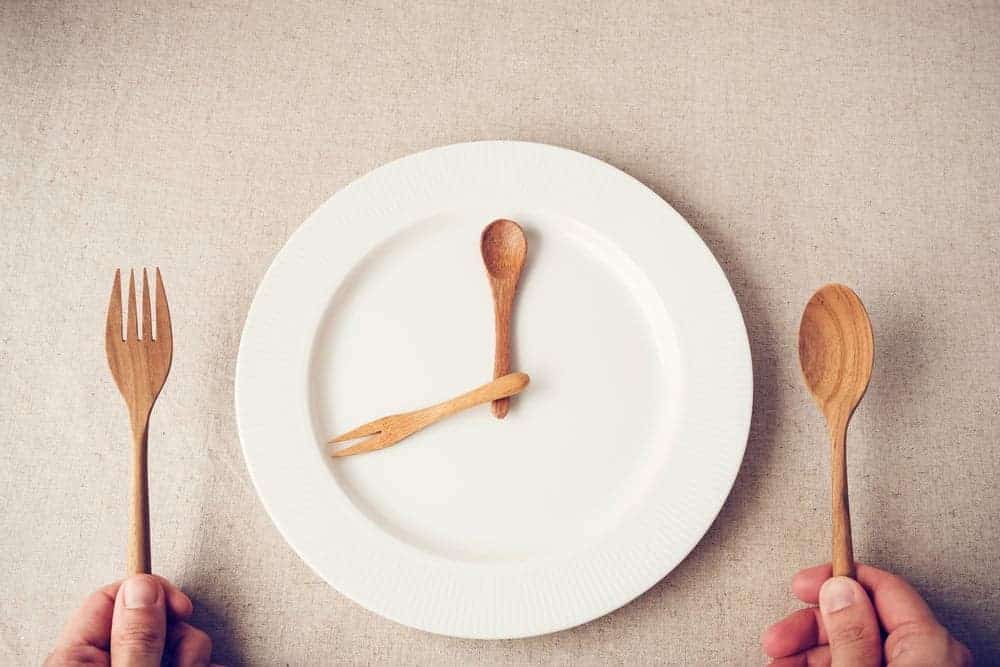 Scheinfasten mit der Prolon Diät, leerer Teller Holzbesteck warten auf das Essen