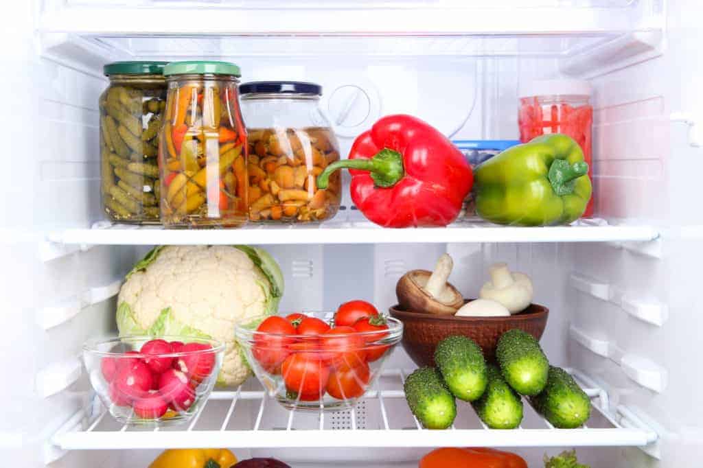 Blick in einen mit frischem und eingelegtem Gemüse gefüllten Kühlschrank